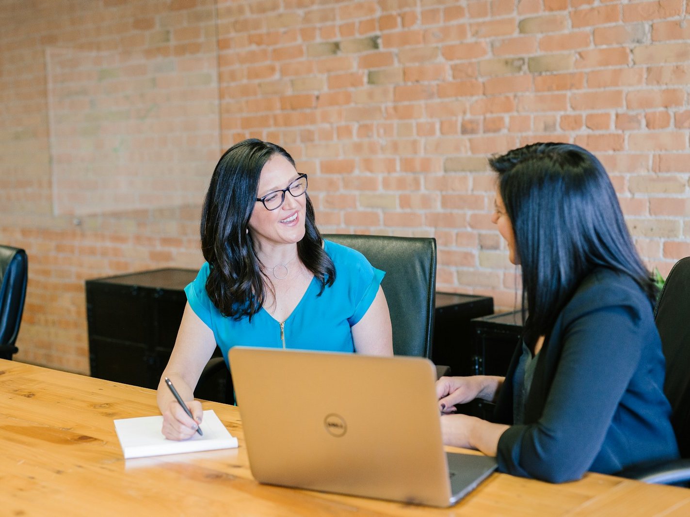 A career services advisor meeting with a student, laptop open on the desk